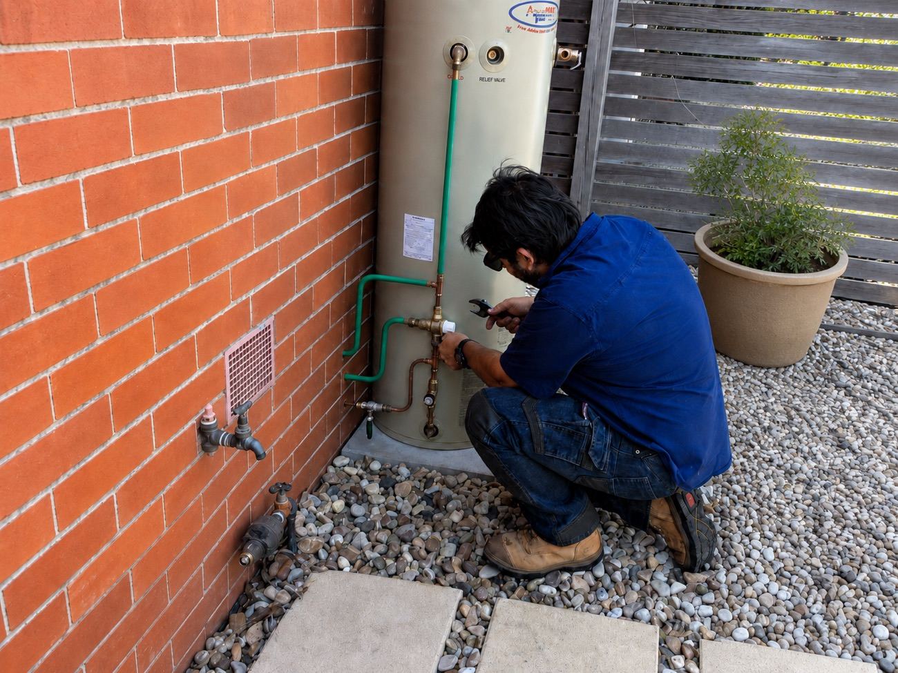 At-Ease Plumbing plumber servicing a hot water system
